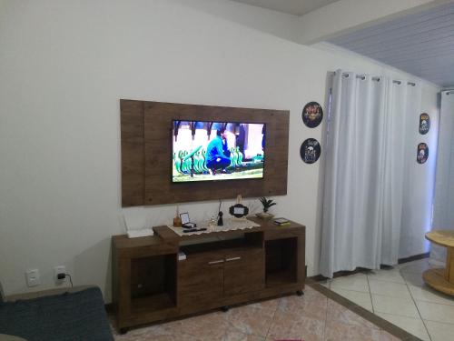 a living room with a flat screen tv on the wall at Harmonia Haus in Blumenau