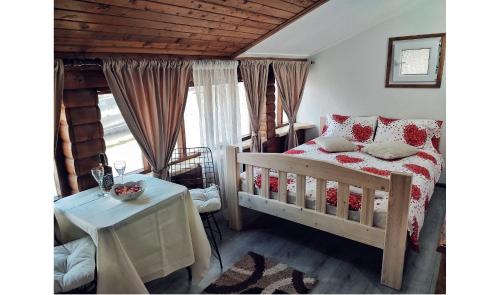 Un dormitorio con una cama y una mesa y una ventana. en Apartman Wooden II, en Žabljak