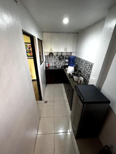 a small kitchen with white cabinets and a black counter at House to rent in a Gated Community with 24hr Security in Lawa-an
