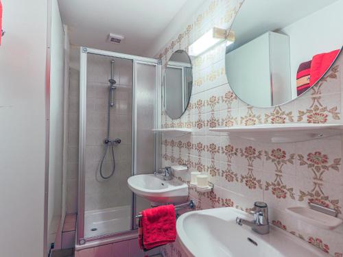 bagno con lavandino, doccia e specchio di Feilgrub 2 a Westendorf