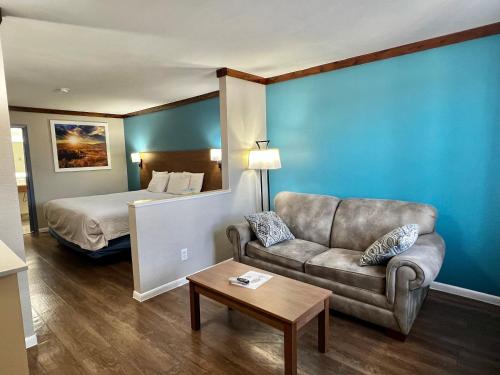 フレデリックスバーグにあるDays Inn by Wyndham Suites Fredericksburgのソファとベッド付きのホテルルーム