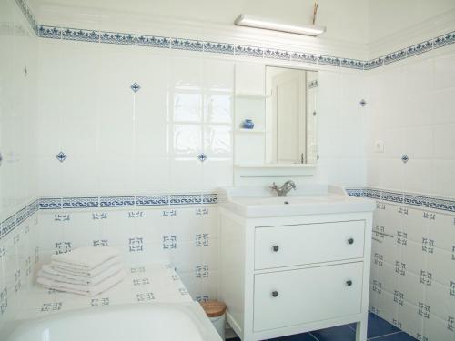 Baño blanco con lavabo y bañera en Villa de Montaigu, en Montaigu-de-Quercy