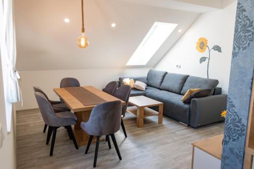 sala de estar con mesa y sofá en Prima Countryside Apartments, en Žirovnica