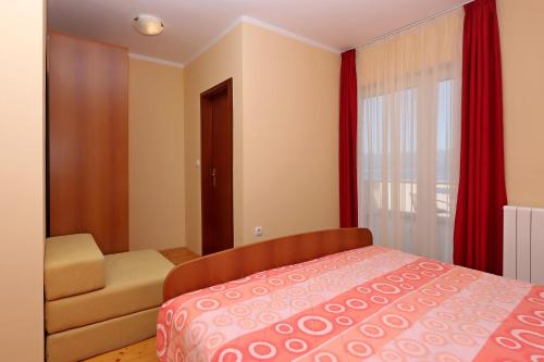 um quarto com uma cama, uma cadeira e uma janela em Double Room Vrbnik 5299b em Vrbnik