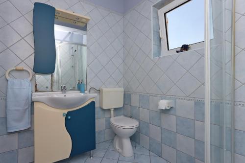 a bathroom with a sink and a toilet and a window at Double Room Vrbnik 5299c in Vrbnik
