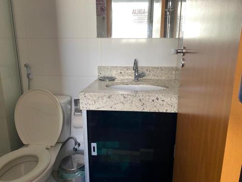 a small bathroom with a toilet and a sink at Everest Flat Service - Apartamento 301 in Caldas Novas