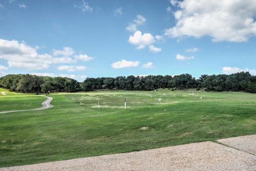 a large green field with trees in the background at Beach and Pool Access at Lake Travis Family Getaway! in Point Venture