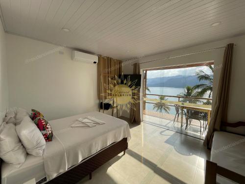 a bedroom with a bed and a view of the ocean at Residencial Solariun Ilhabela in Ilhabela