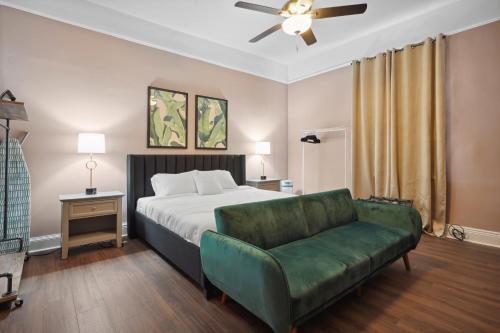 a bedroom with a bed and a green couch at The Balcony House II in New Orleans