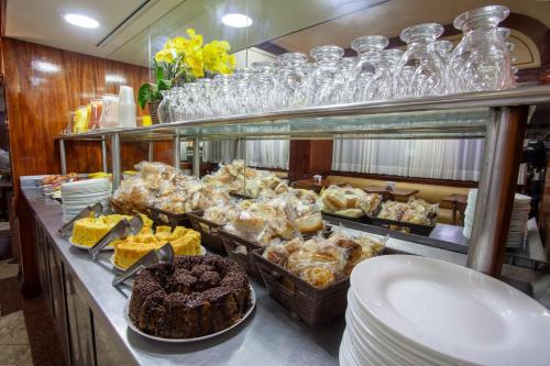 a buffet with cakes and other food on a table at Hotel Nacional Inn Belo Horizonte in Belo Horizonte