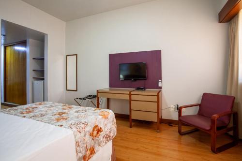 - une chambre avec un lit, un bureau et une télévision dans l'établissement Hotel Nacional Inn Belo Horizonte, à Belo Horizonte