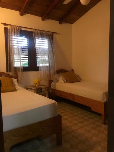 1 dormitorio con 2 camas y ventana en La Cortesana in Las Terrenas, en Las Terrenas