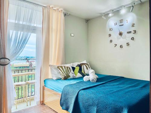 sypialnia z łóżkiem z oknem i zegarem w obiekcie J&J Residences, Complete Accommodation with a View w mieście Mactan