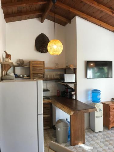 a kitchen with a wooden table and a refrigerator at La Cortesana Cozy Two Bedroom Apartment Steps to the Beach in Las Terrenas