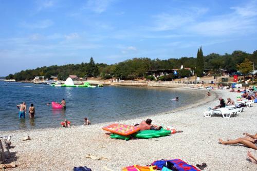 a group of people on a beach near the water at Apartments with a parking space Tar, Porec - 6943 in Tar