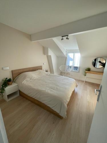 een slaapkamer met een groot bed en een houten vloer bij Nanterre : Super appartement tout confort in Nanterre
