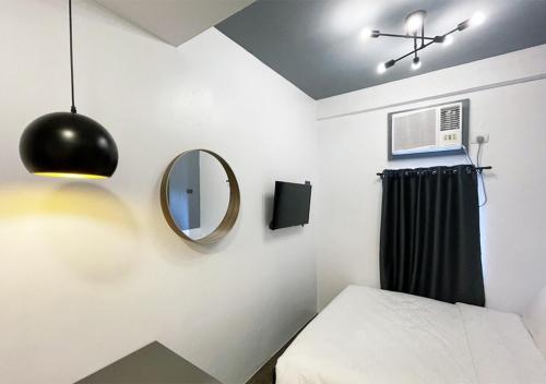 a bedroom with a mirror and a bed at mySTAY Hotel BGC East in Manila