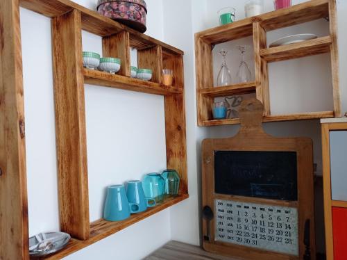 a kitchen with wooden shelves and a calendar on a wall at NEW! Great Location! Vibrant Downtown, Talpiot Market, Flea Market, Carmel Beach, close to everywhere in Haifa