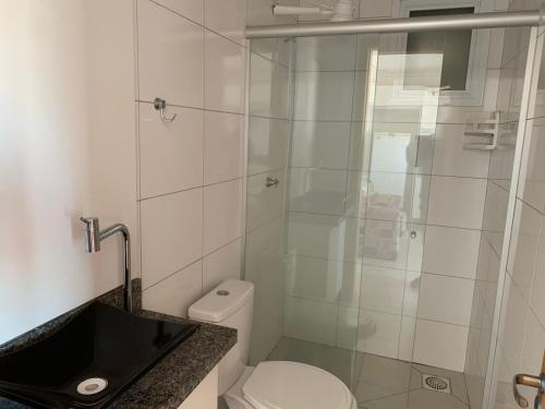 a bathroom with a toilet and a glass shower at Novo apto com 100 metros da Av. Brasil in Passo Fundo