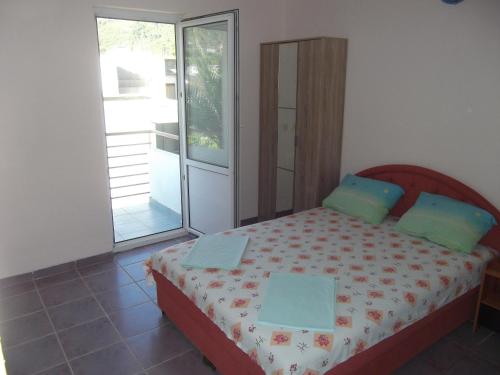 een slaapkamer met een bed en een glazen schuifdeur bij Apartments Jovan in Sutomore