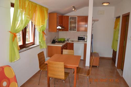 a kitchen with a wooden table and chairs in a room at Apartments and rooms by the sea Jakisnica, Pag - 4160 in Lun