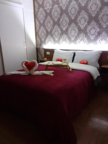 a bedroom with a bed with a heart on it at Hospedagem Souza in Urubici