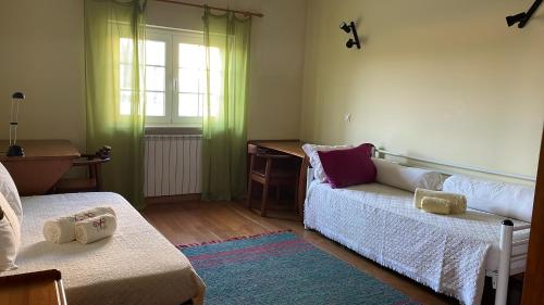 Zimmer mit 2 Betten, einem Schreibtisch und einem Fenster in der Unterkunft Villa Baleia, São Julião Beach - Ericeira in Ericeira