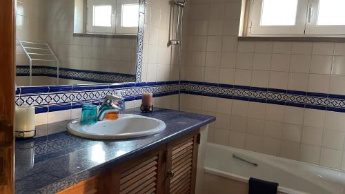 a bathroom with a sink and a mirror and a tub at Villa Baleia, São Julião Beach - Ericeira in Ericeira