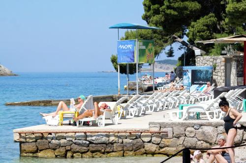 - un groupe de personnes assis sur des chaises à la plage dans l'établissement Apartments by the sea Cavtat, Dubrovnik - 8966, à Cavtat