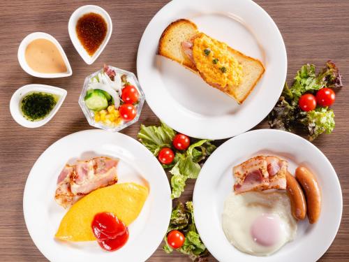 a table with white plates of food on it at Utsunomiya Tobu Hotel Grande in Utsunomiya