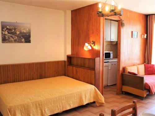 1 dormitorio pequeño con 1 cama y cocina en Appartement Vars, 1 pièce, 4 personnes - FR-1-330B-195, en Vars