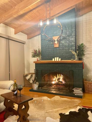 a living room with a fireplace and a table at Two Mountains Lodge - Modern Alpine Retreat with Spa - 3mins to Mt Buller in Mount Buller