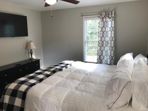 um quarto com uma cama branca e uma janela em Brand New 3 bedroom 2 bath Home (Built 2022) em Huntsville