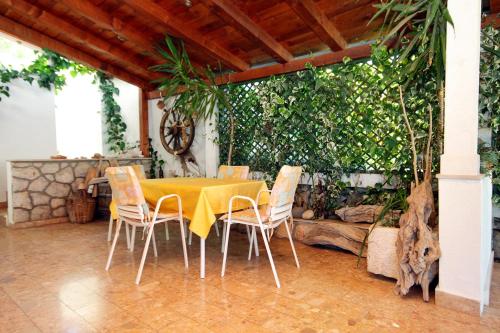 a yellow table and chairs in a patio at Triple Room Vrboska 540e in Vrboska