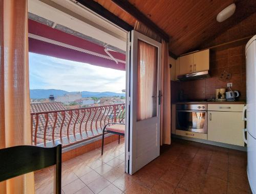 a kitchen with a door open to a balcony at Apartments and rooms by the sea Vrboska (Hvar) - 540 in Vrboska