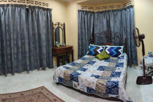 a bedroom with a bed and a mirror and curtains at Mai KKB Homestay in Kuala Kubu Bharu Taman Juta in Kuala Kubu Bharu