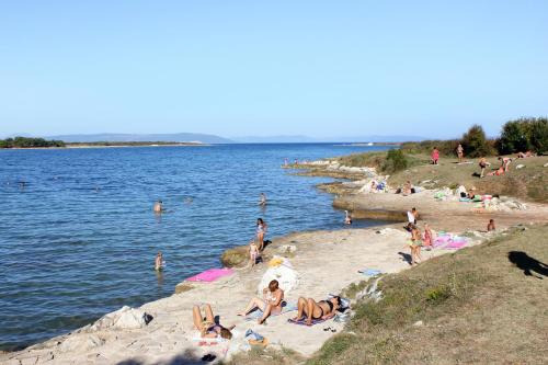 a group of people on a beach near the water at Apartments with a parking space Liznjan, Medulin - 11152 in Ližnjan