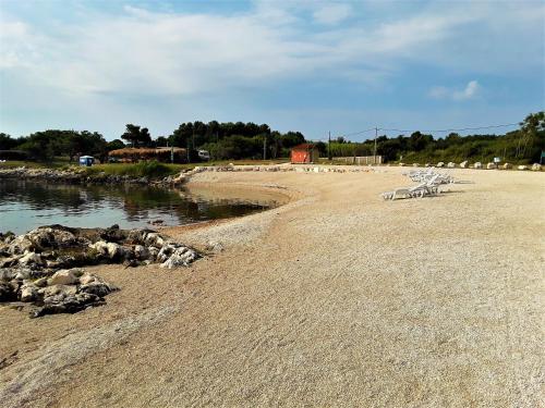 a group of chairs sitting on a beach at Apartments with a parking space Liznjan, Medulin - 11152 in Ližnjan