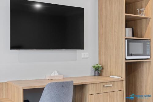a flat screen tv hanging on a wall in a room at Hive Hotel, Moruya in Moruya