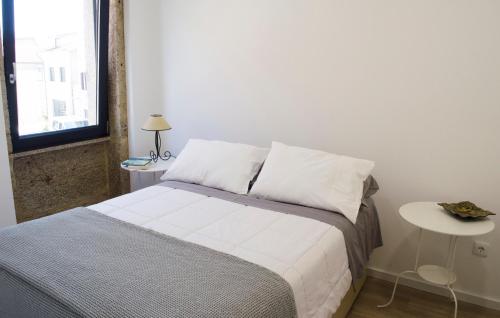 ein Schlafzimmer mit einem Bett und einem Tisch und einem Fenster in der Unterkunft Sabor@Arte in Couto de Esteves