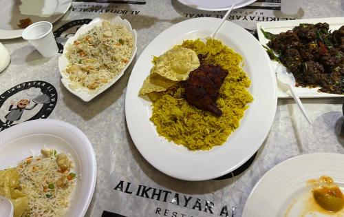 a table topped with plates of food on a table at ARABIAN HOLIDAY RESORT WITH SWIMMING POOL IN IDUKKI Calvary Mount in Idukki