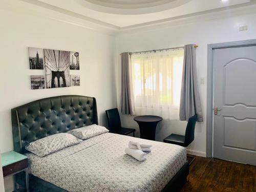 a bedroom with a bed and a chair and a window at 3 Peaks Resort & Boutique Hotel in Lipa
