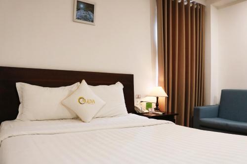a hotel room with a bed and a blue chair at ALUNA Ben Thanh Hotel in Ho Chi Minh City