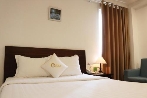 a hotel room with a bed and a chair at ALUNA Ben Thanh Hotel in Ho Chi Minh City