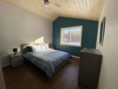 1 dormitorio con cama y ventana en Dream vacation cottage for all seasons 4 bdr/2bath, en Bancroft