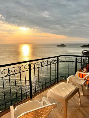 Un balcón con sillas y vistas al océano. en El peñón del rodadero, en Santa Marta