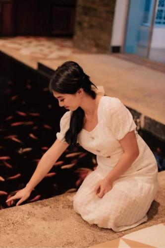 a woman in a white dress sitting on the ground at HOTEL Pinc in General Santos