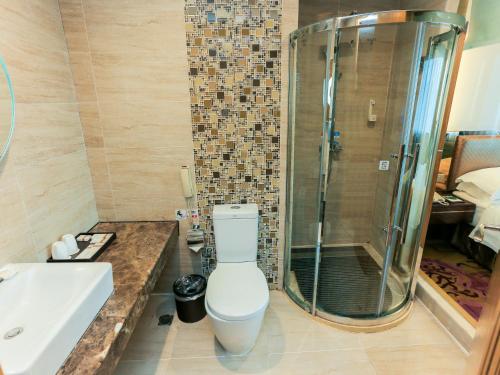 a bathroom with a toilet and a sink and a shower at Guangzhou Easun Guotai hotel in Guangzhou