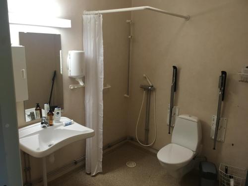 La salle de bains est pourvue d'un lavabo, d'une douche et de toilettes. dans l'établissement Hostel Svedjegården, à Nybble