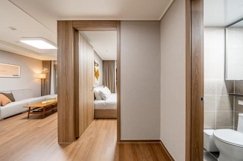 a bathroom with a toilet and a bedroom at Urbanstay Sokcho beach C in Sokcho